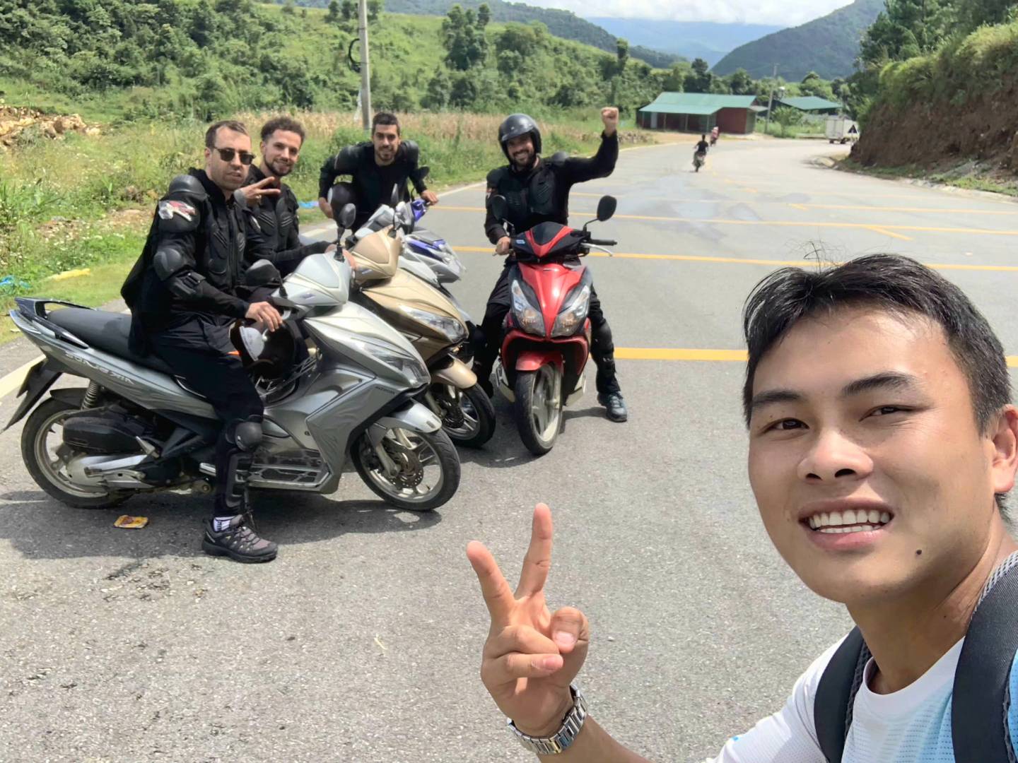 Hmong local guide with four tourists on a Sapa trekking and motorbike tour through mountain villages