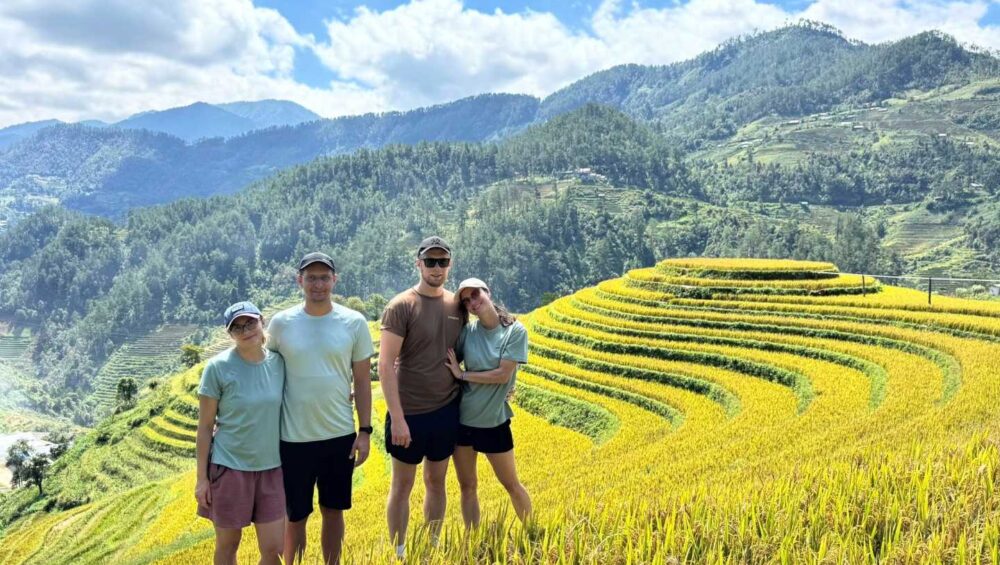 four tourists trekking on gorden rice field