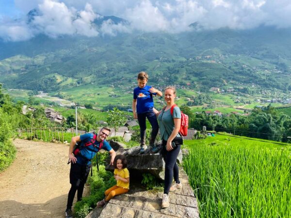 family trekking through rice fields