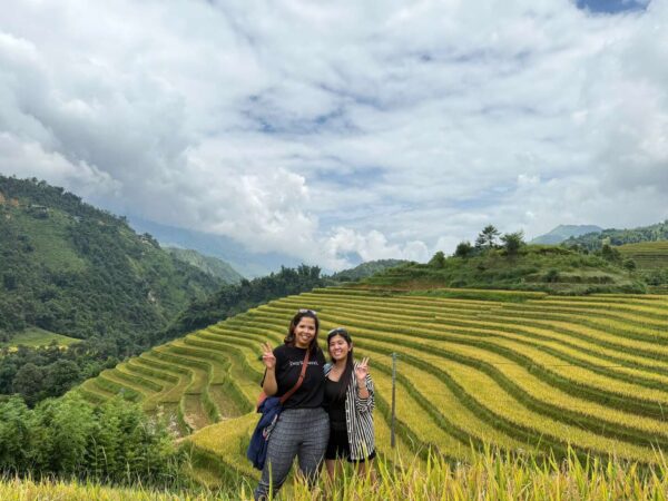 two traveller trekking through rice field